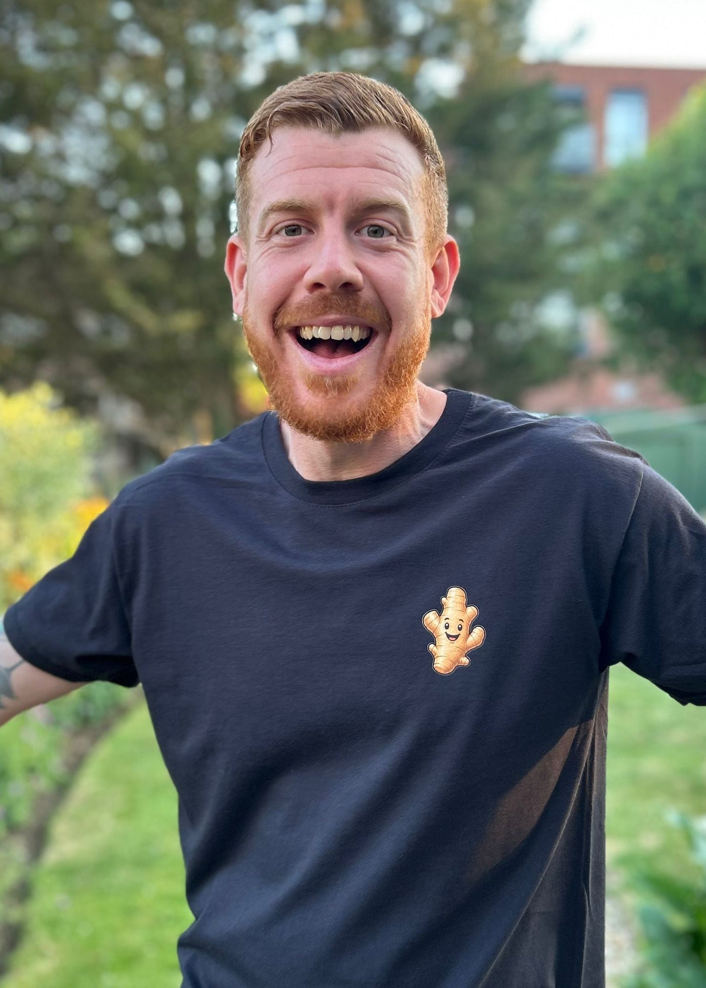Man wearing a black t-shirt with a logo outdoors