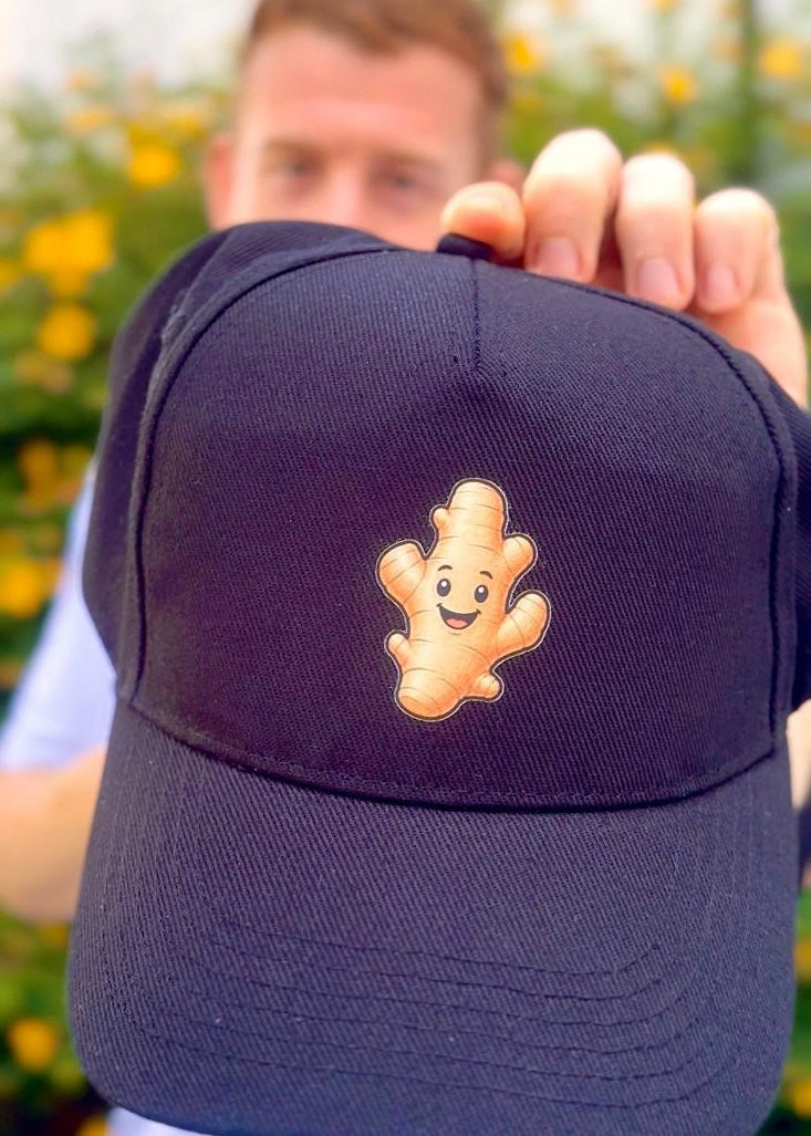 Person holding a navy blue cap with a cartoon character on a blurred background