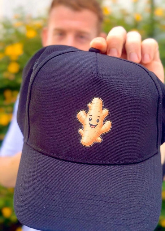 Person holding a navy blue cap with a cartoon character on a blurred background